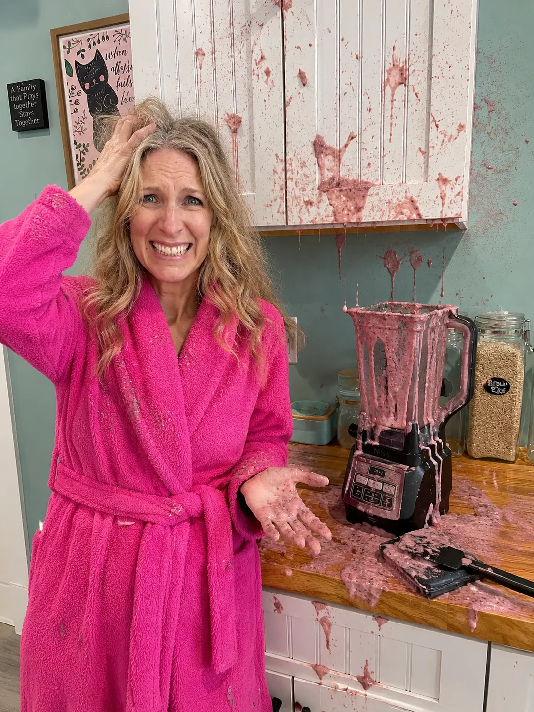Lizzy in the kitchen with an blender mess and smoothie all over the counter, cabinets, and walls.