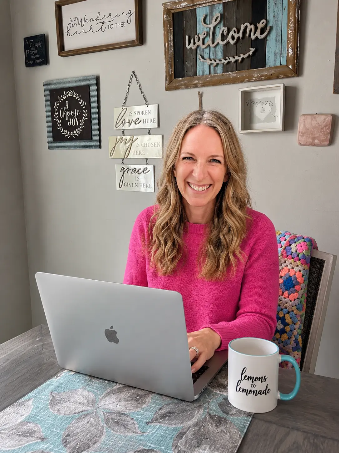Lizzy sits at a dining room table working with a new tech software.