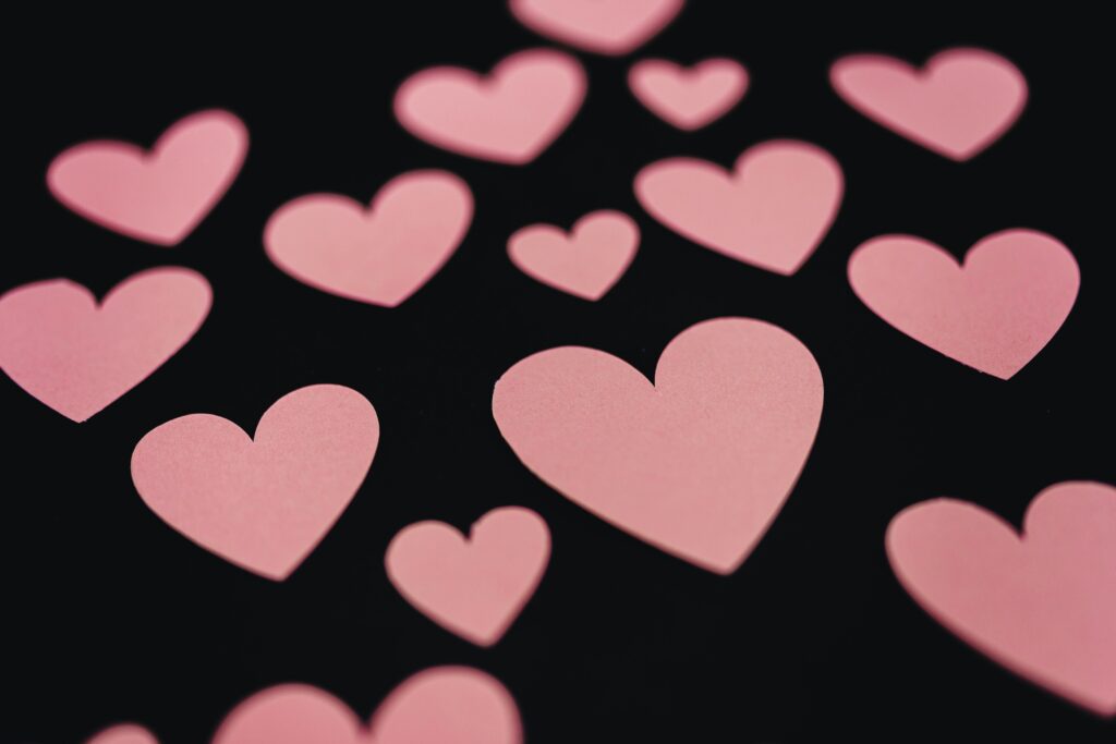 several pink hearts on a black backdrop